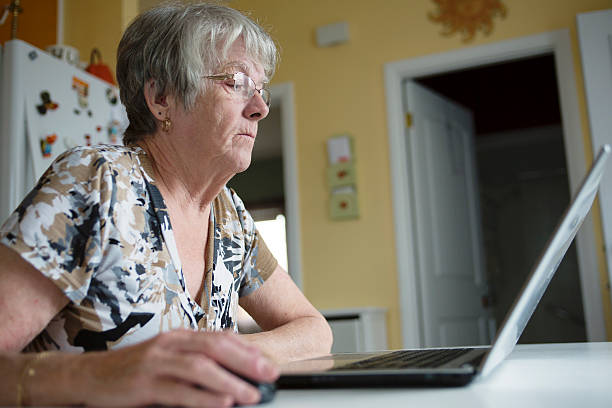 istock senior woman working on her laptop in her kitchen table 484766862