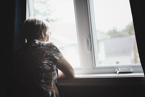 lonely 60 años de edad se senior en apartamento - desaturado fotografías e imágenes de stock