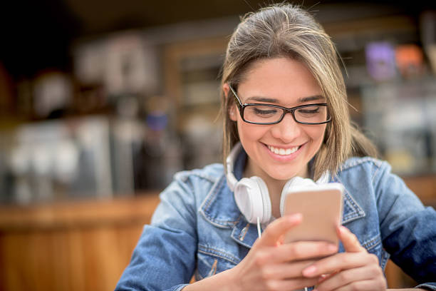istock Woman at a coffee shop texting on her phone 484771368
