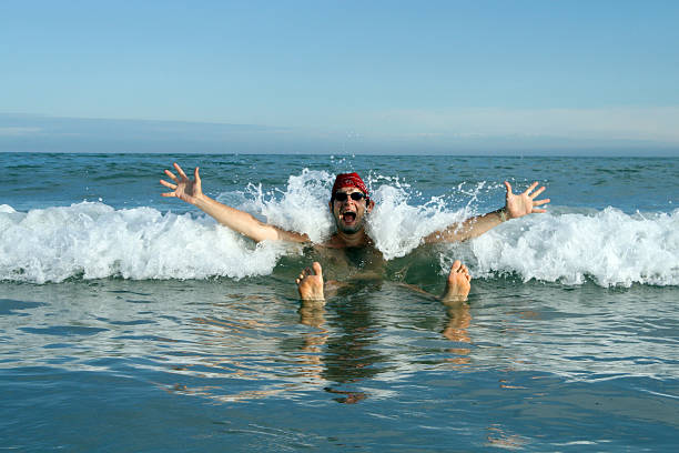 istock Man with red cap in the waves of the sea 484771380