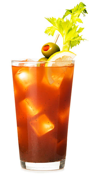 Bloody Mary Cocktail on White Bloody mary in pint glass with pimento olive lemon and celery isolated on white background bloody mary stock pictures, royalty-free photos & images