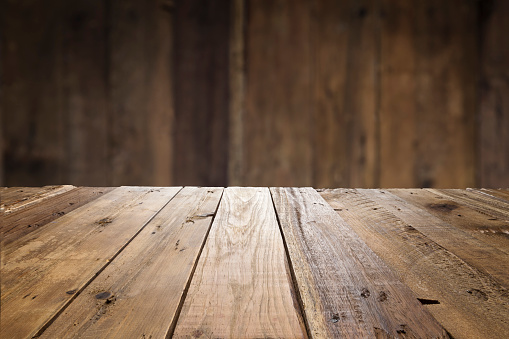 Empty wood table with defocused vertical table background. Ideal for product display on top of the table.