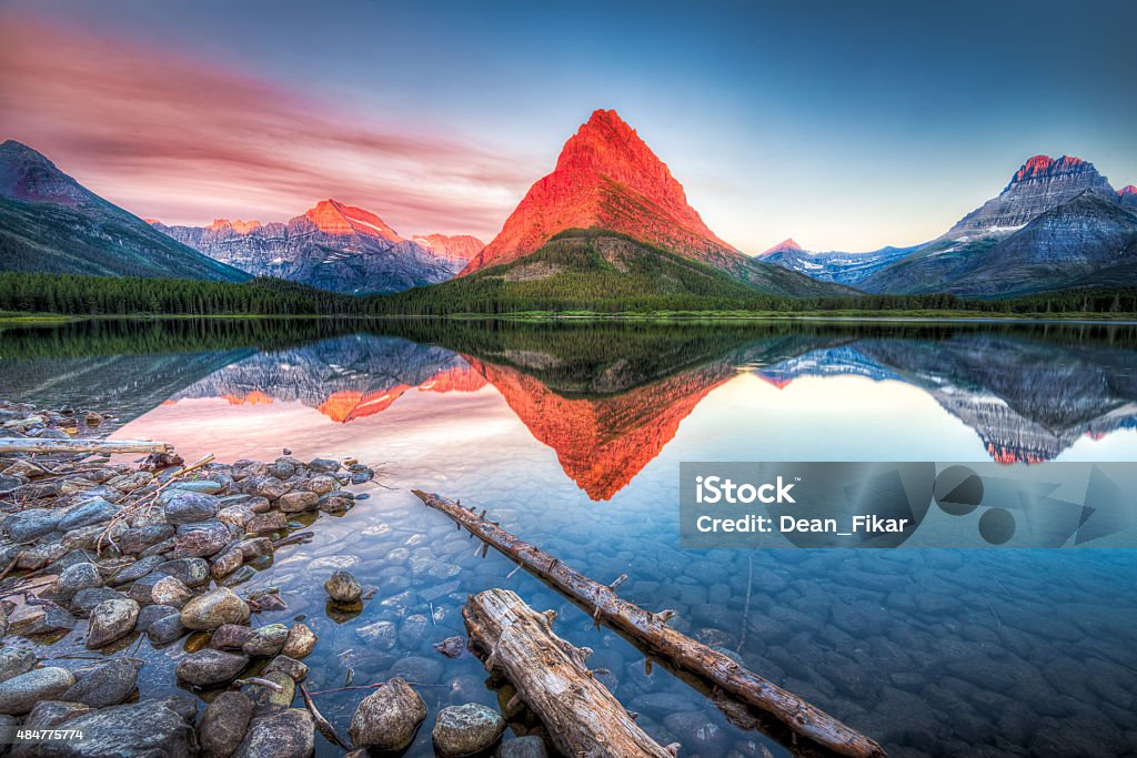 Swiftcurrent Lake at Dawn Stunning reflections on Swiftcurrent Lake in northern Montana at sunrise US Glacier National Park Stock Photo