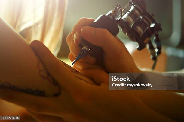 Tattoo Master Tattooing On The A Girl Arm Stock Photo - Download Image Now - 20-24 Years, 2015, Activity