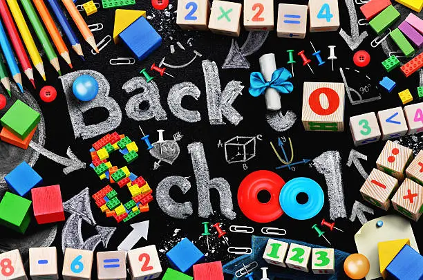 School supplies on black schoolboard background. Back to school concept