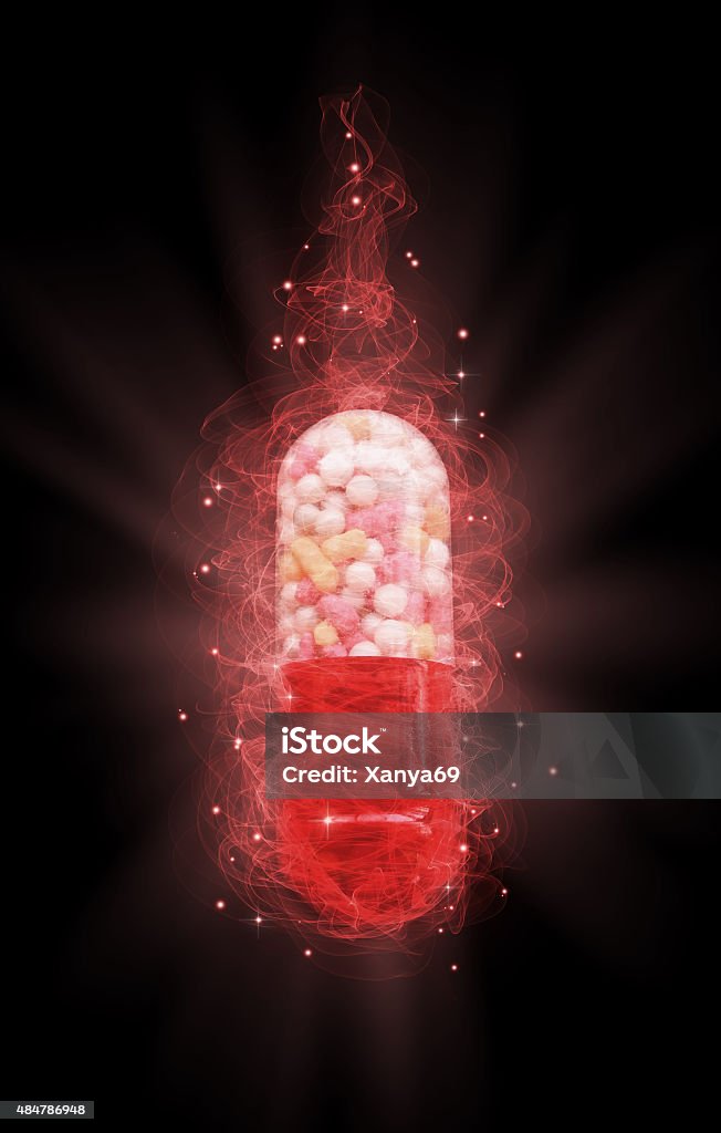 magic pill miraculous magic pill on a black background Capsule - Medicine Stock Photo