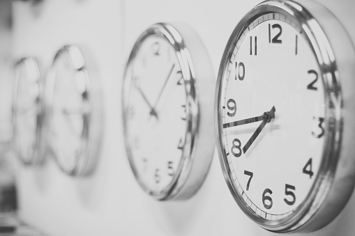 Many clocks on the wall. Black and white image.