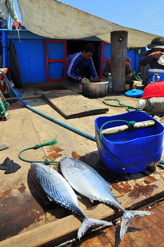Nha Trang, Vietnam - May 4, 2012: Fisherman is preparing lunch on a tuna fishing boat in the sea of Nha Trang bay