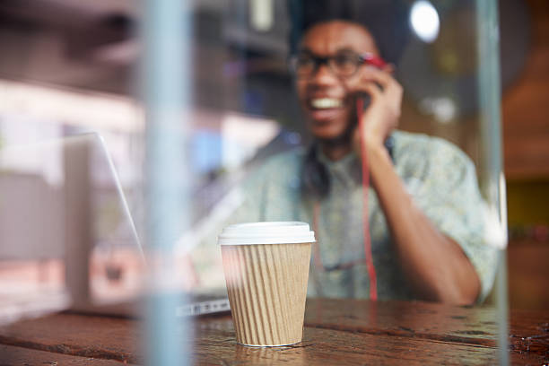 istock Businessman Using Phone Working On Laptop In Coffee Shop 484793646