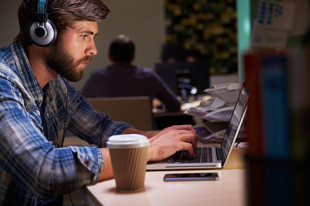 istock Office Worker With Coffee At Desk Working Late On Laptop 484794562
