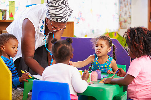 istock Teacher helping kids in a preschool class 484794646