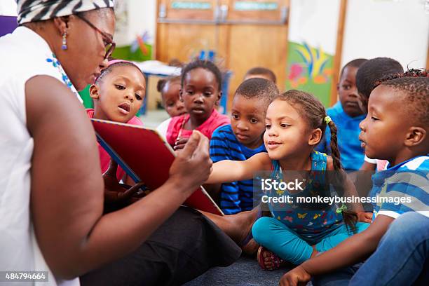 Teacher Reading A Book With A Class Of Preschool Children Stock Photo - Download Image Now