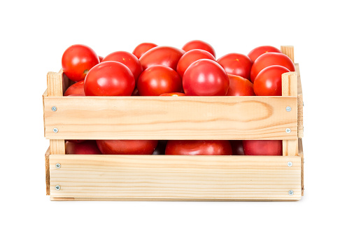 Fresh tomatoes in wooden box isolated on white background