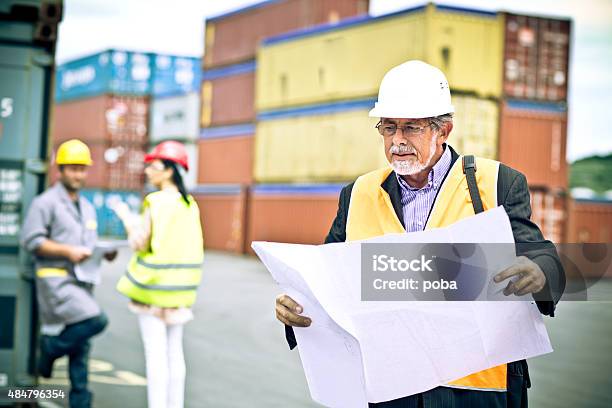 Inspector With Commercial Dock Workers Stock Photo - Download Image Now - 2015, Adult, Adults Only