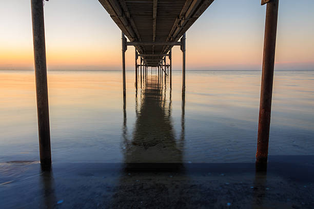 Photo of Under the Jetty at Sunrise sunset time on the beach