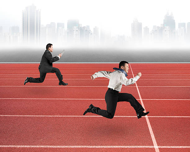 istock Two businessmen running on red track 484800576