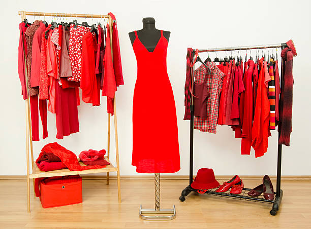 istock Dressing closet with red clothes arranged on hangers. 484800588