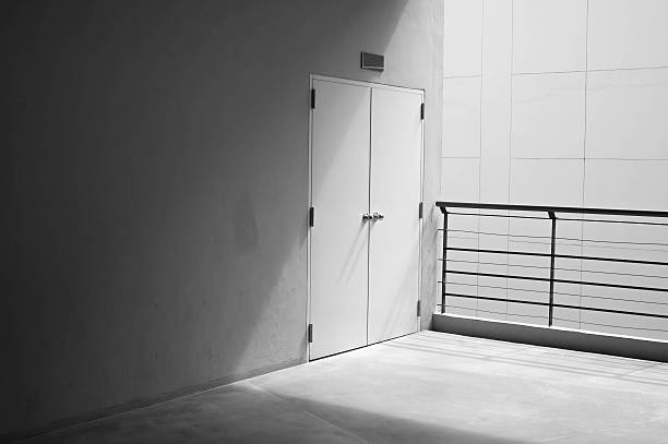 istock Concrete wall and door with light from corner 484800760