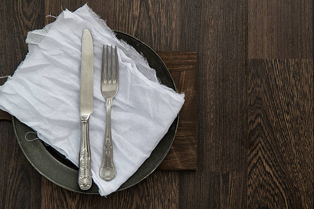 istock Vintage cutlery on muslin cloth on pewter plate 484801052