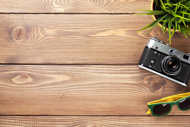 istock Camera, sunglasses and flower on office desk 484803978