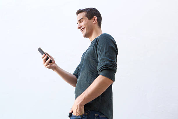 istock Smiling man walking and looking at mobile phone 484806920