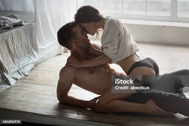 Passionate Couple Kissing Stock Photo - Download Image Now - Bed - Furniture, Flooring, Jeans