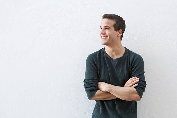 istock Smiling man standing against white background with arms crossed 484806942