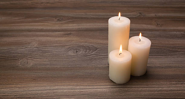istock White candles on the board from oak 484807138