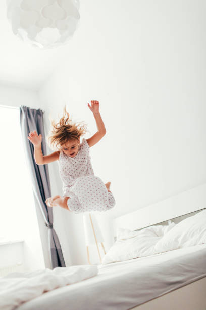 istock Little Girl Jumping On The Bed. 484807356