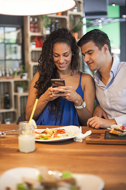 istock Beautiful couple sitting in a cafe and using smartphone. 484808658