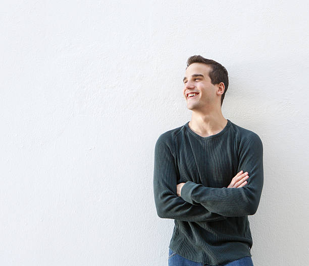 istock Young man standing against white background with arms crossed 484808730