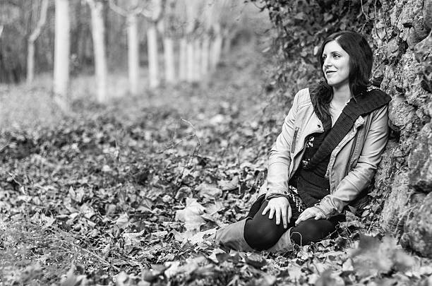 istock young girl autumn seated smile thinking black and white 484809606