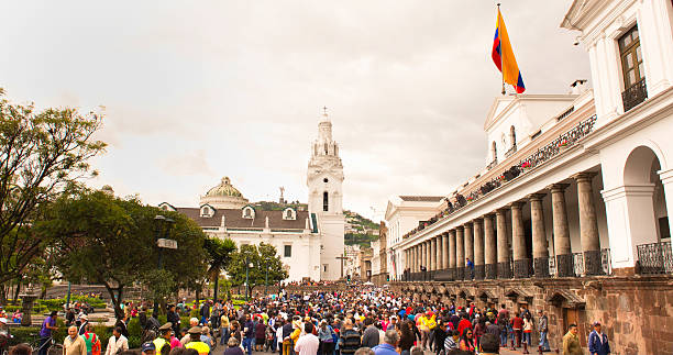 Quito, Ecuador - March 2, 2014: Colorful crowds walk through Independence Square in front of the Presidential Palace in Quito,Ecuador,  on a Sunday during Carnival in 2014.