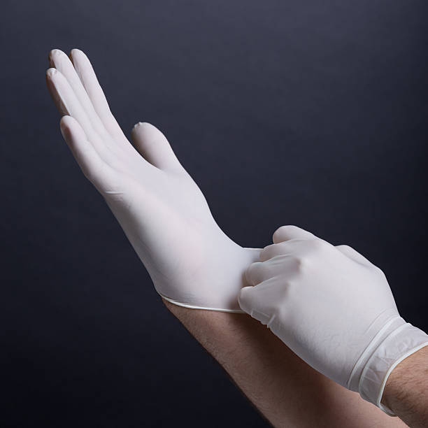 Male hands putting on latex gloves stock photo