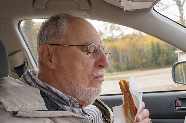 istock senior man with expressive face eating  fast foods 484812417