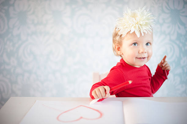 Baby girl drawing a heart