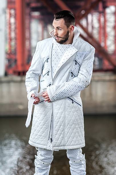 Stylish man with a beard in a white leather coat is stock photo