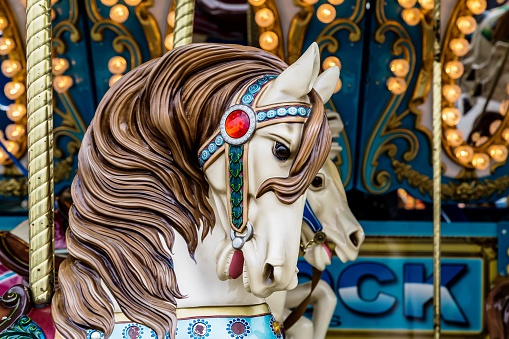 Beautiful carousel horse looking down on a colorful background. Carousel horse closeup. Beautiful merry go round horse on colorful background