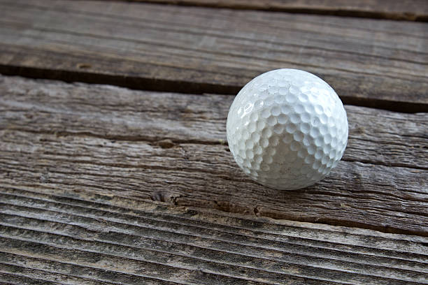 istock Old used golf ball on wooden background 484821496