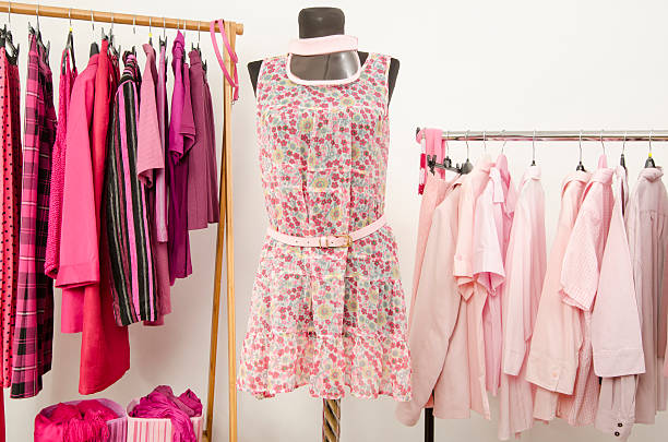 istock Dressing closet with pink clothes arranged on hangers. 484822386