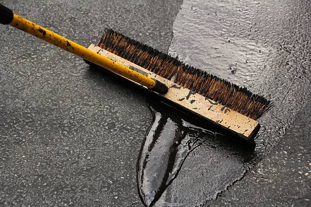 istock Asphalt driveway sealing with flat brush 484823372
