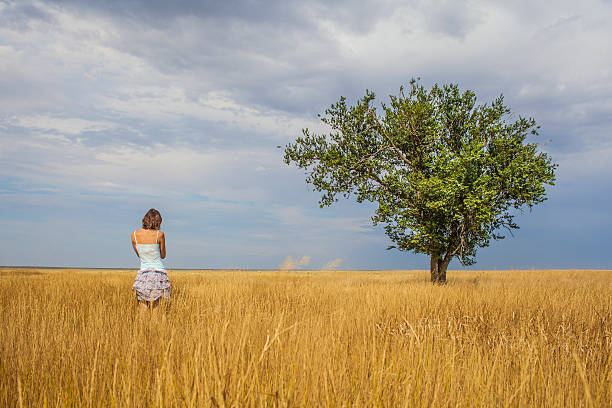 istock woman standing in a clearing near a large tree 484823818