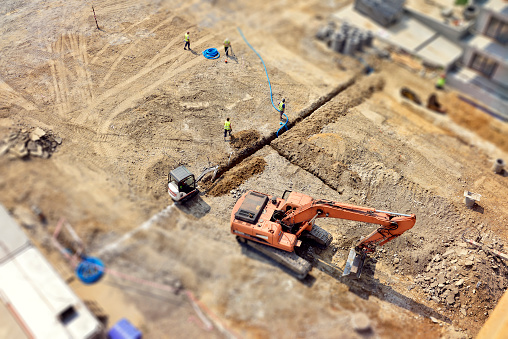 Workers, Engineers digging in ground, sewer system, street, tilt-shift, above