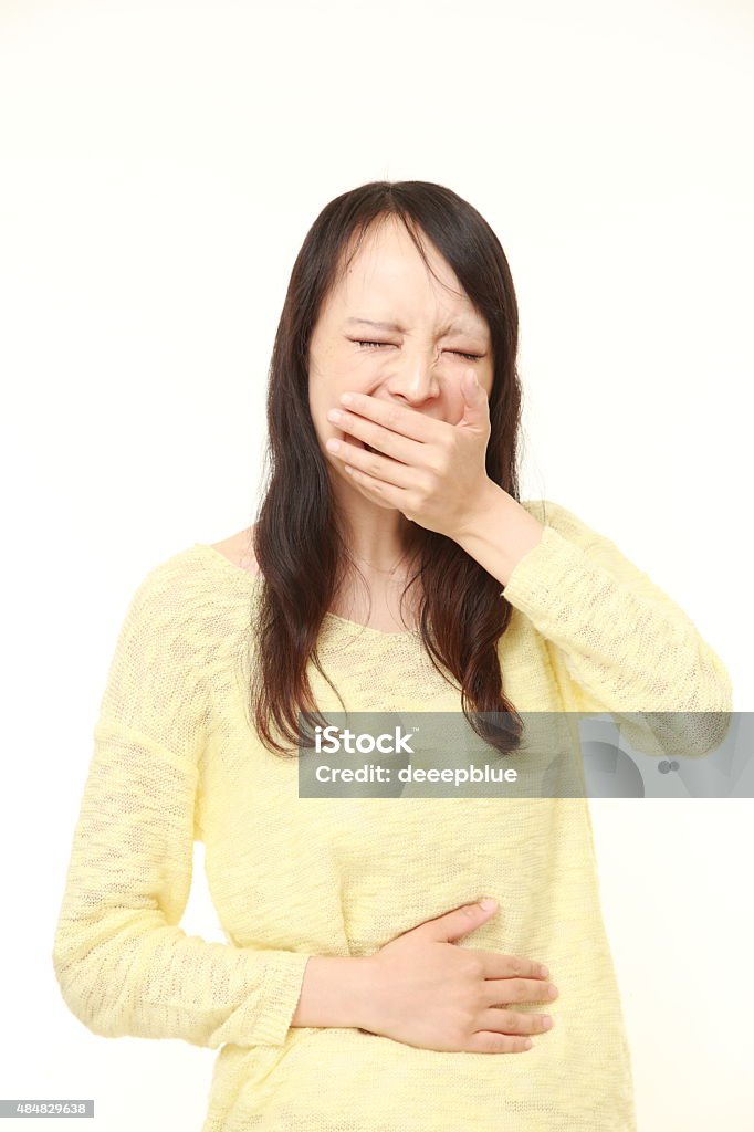 young Japanese woman feels like vomiting studio shot of young Japanese woman on white background 2015 Stock Photo