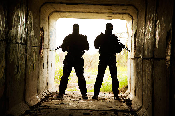 in the tunnel Silhouette of special forces operators with weapons in the tunnel spetsnaz stock pictures, royalty-free photos & images