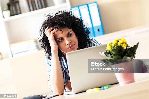 Exhausted Businesswoman Looking At Laptop Stock Photo - Download Image Now - 2015, Adult, Adults Only