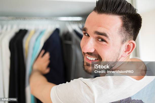 Smiling Man Choosing Clothes Stock Photo - Download Image Now - Closet, Men, Standing