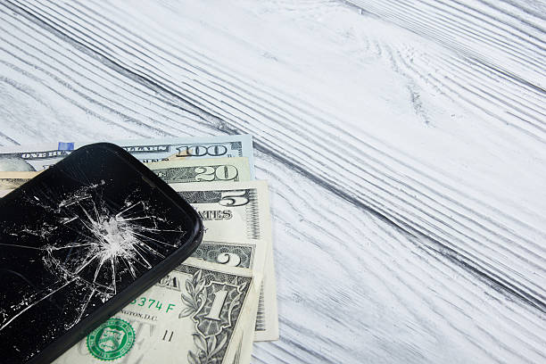 istock Modern broken mobile phone and money on white wooden background. 484830454