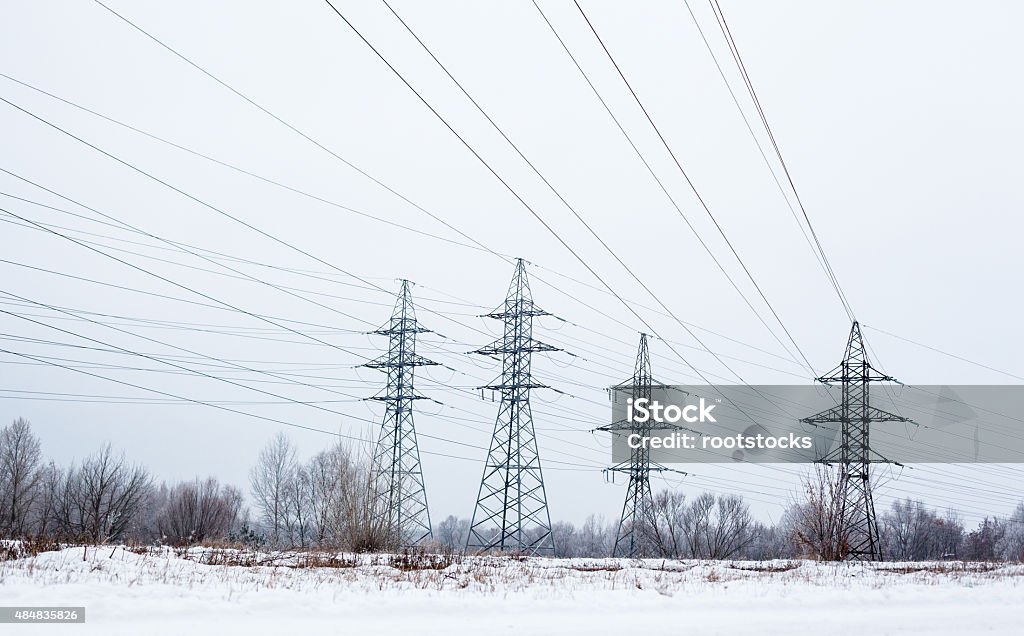 Electricity pylons and power lines in the winter day System of electricity pylons and power lines out-of-town in the winter day. 2015 Stock Photo