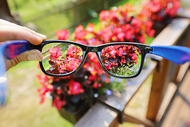 istock eyeglasses in the hand over blurred flower background 484836968